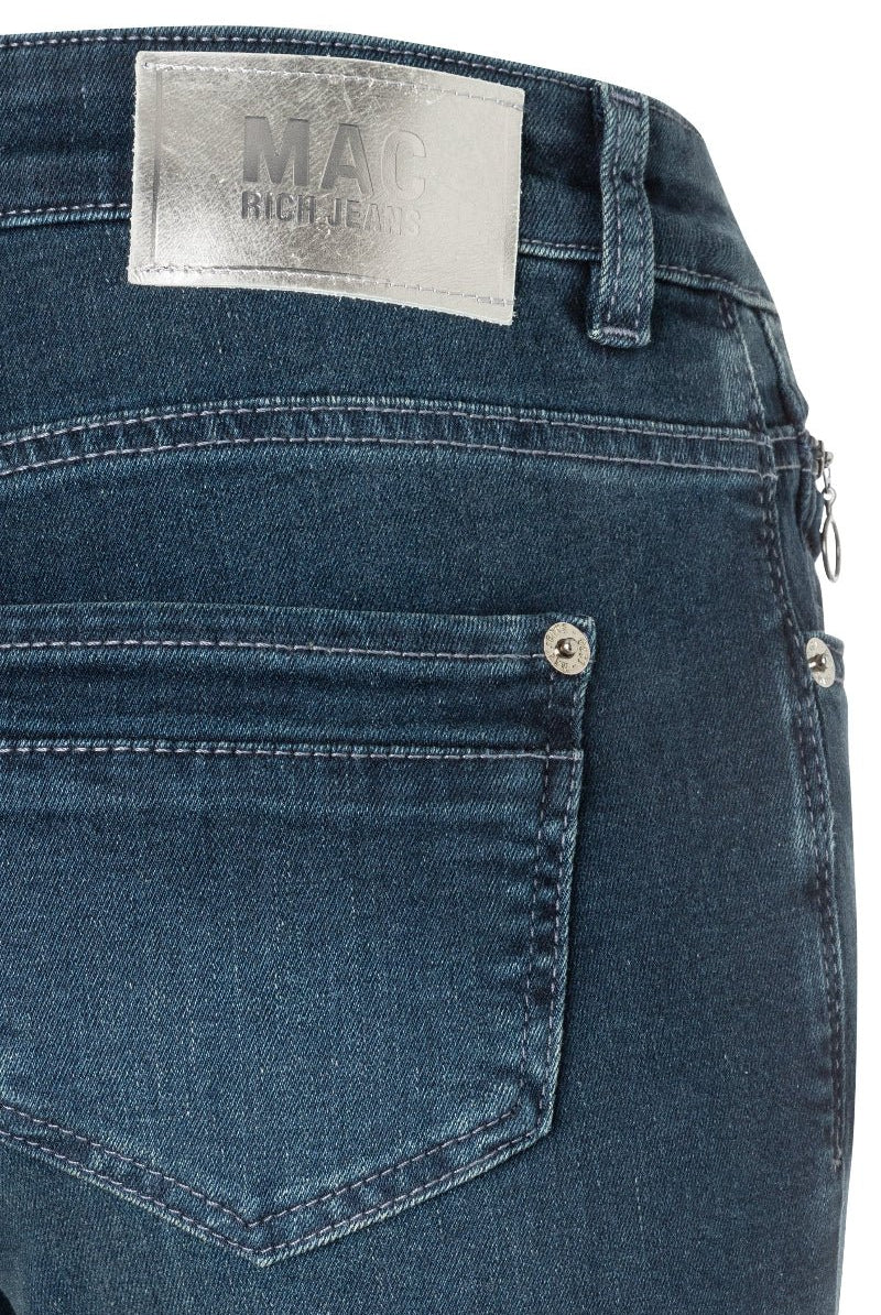 Close-up of blue jeans with a visible brand label on a white background