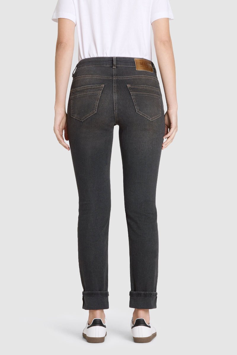 Person wearing black jeans with a white background