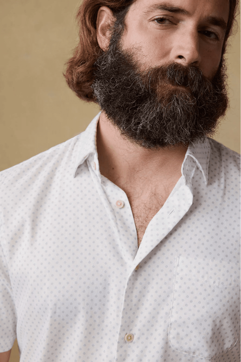 Man wearing a light-colored shirt with a beige background