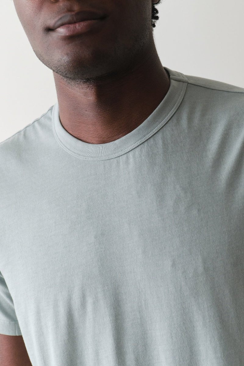 Man wearing a light gray t-shirt against a plain background