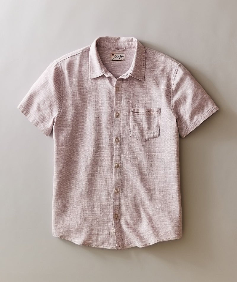 Pink checkered short-sleeve shirt on a light gray background