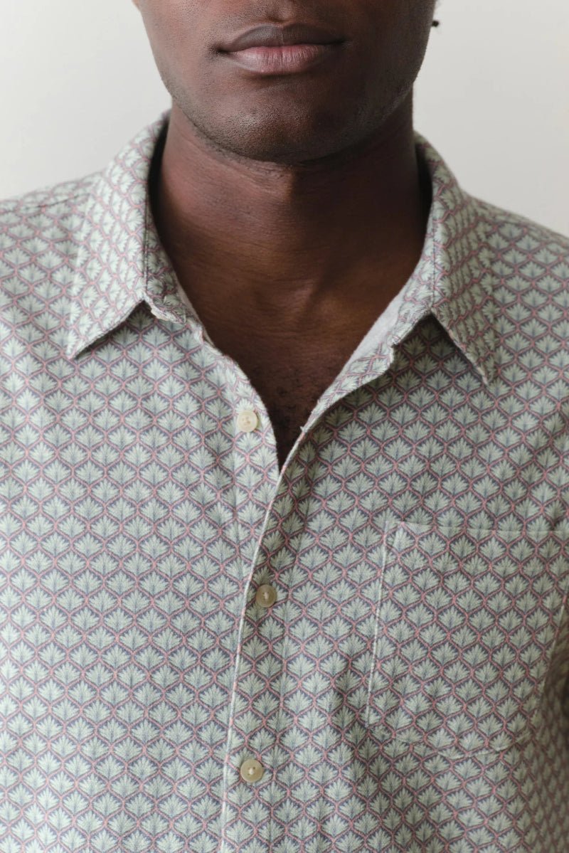 Man wearing a patterned shirt against a plain background