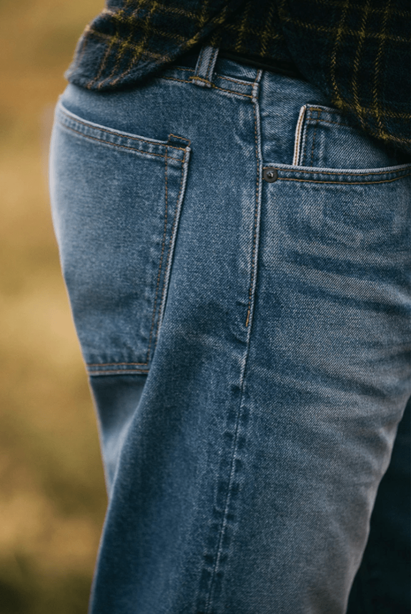Close-up of blue jeans with a blurred natural background
