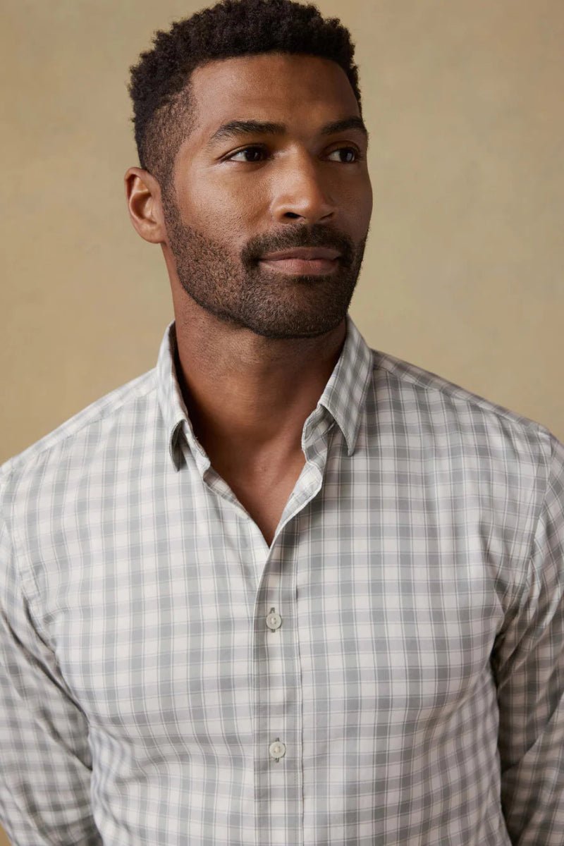 Man wearing a checkered shirt against a beige background