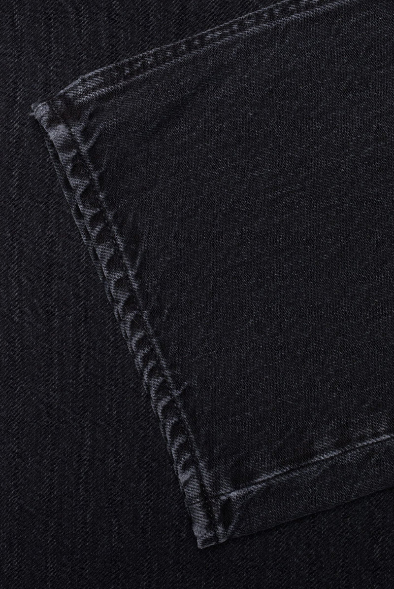 Close-up of black denim fabric with stitching detail