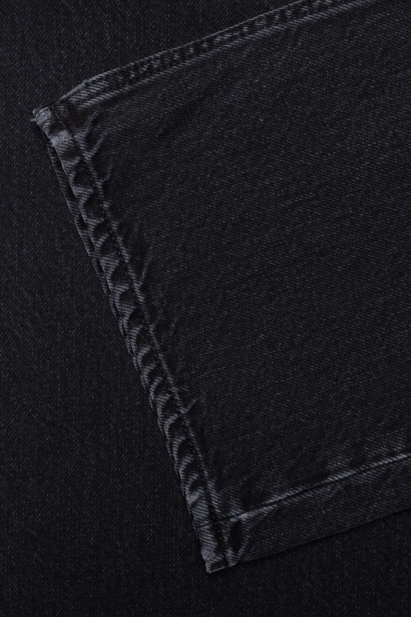Close-up of black denim fabric with stitching detail