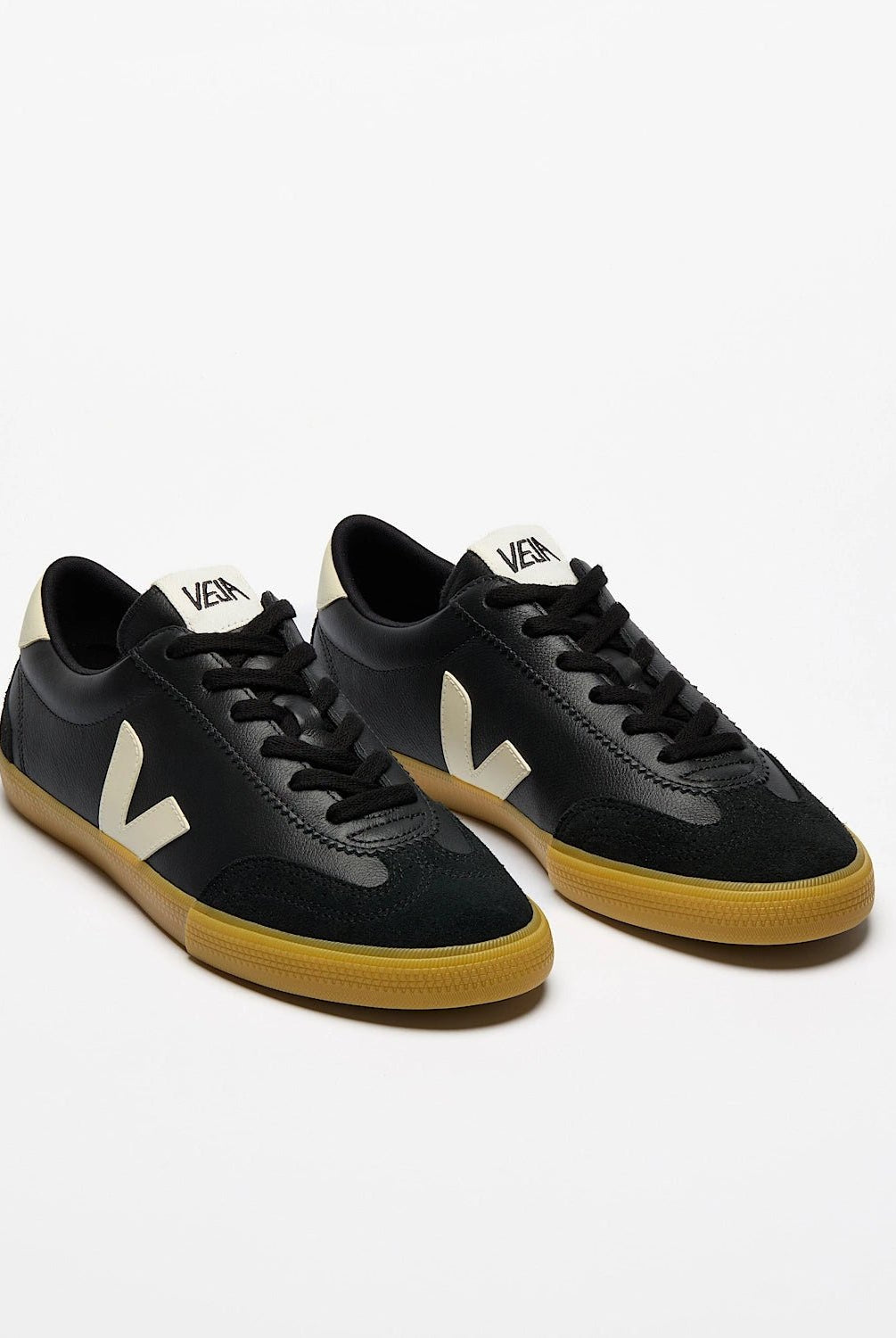 Black sneakers with yellow soles on a white background