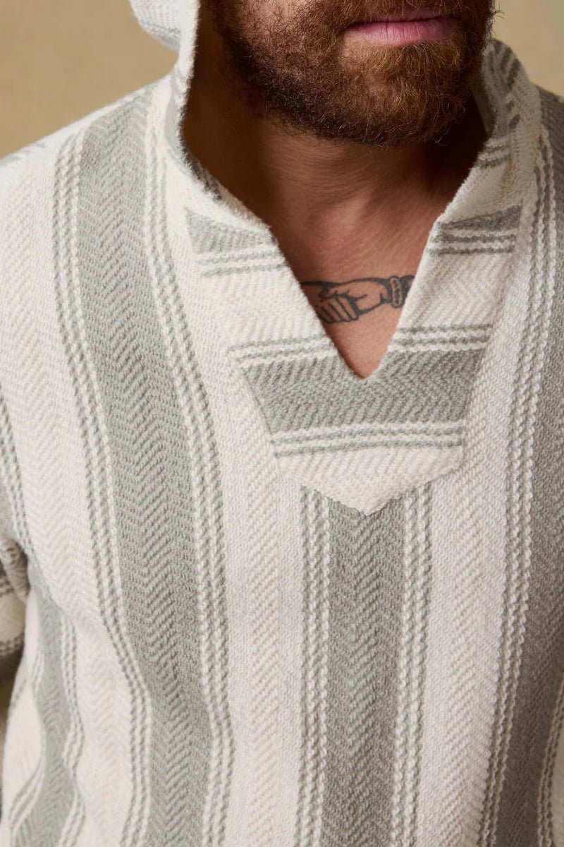 Man wearing a patterned sweater with a neutral background