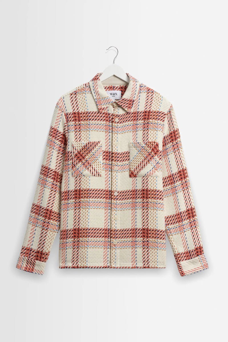 Plaid shirt on a hanger against a white background