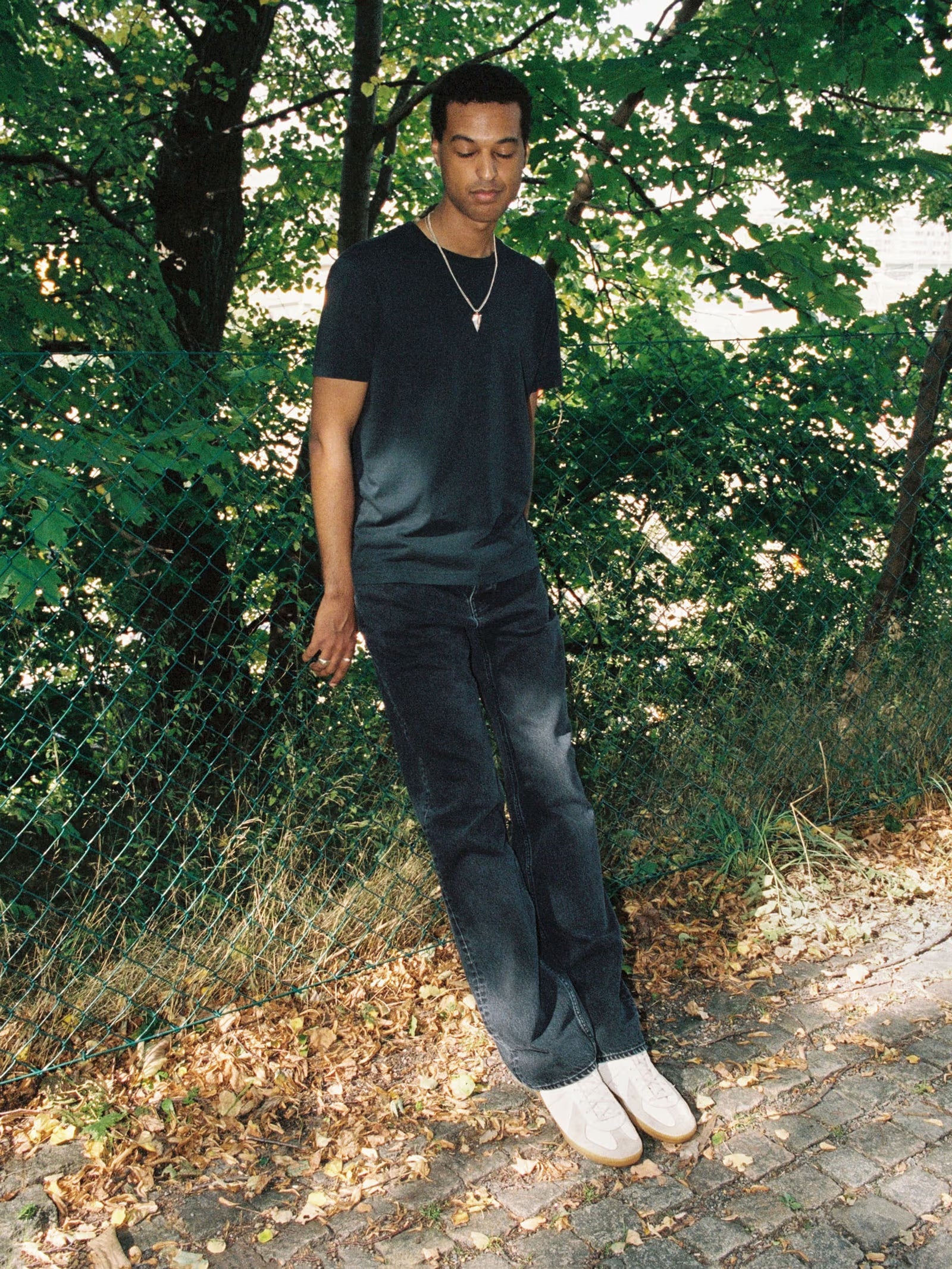 Man standing outdoors with greenery in the background