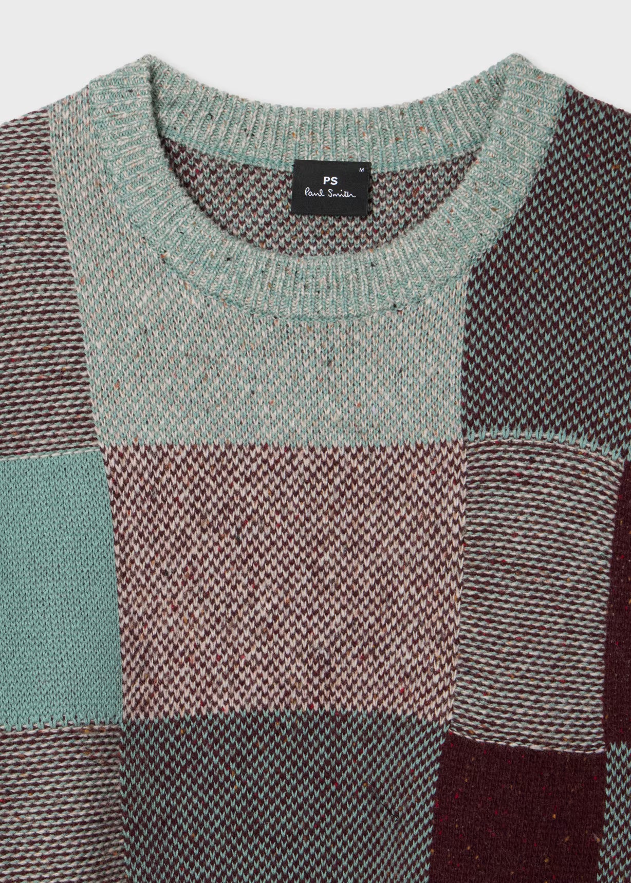 Patchwork sweater with a brand label on a white background