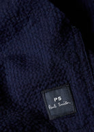 Close-up of a navy blue textured fabric with a 'PS Paul Smith' label.