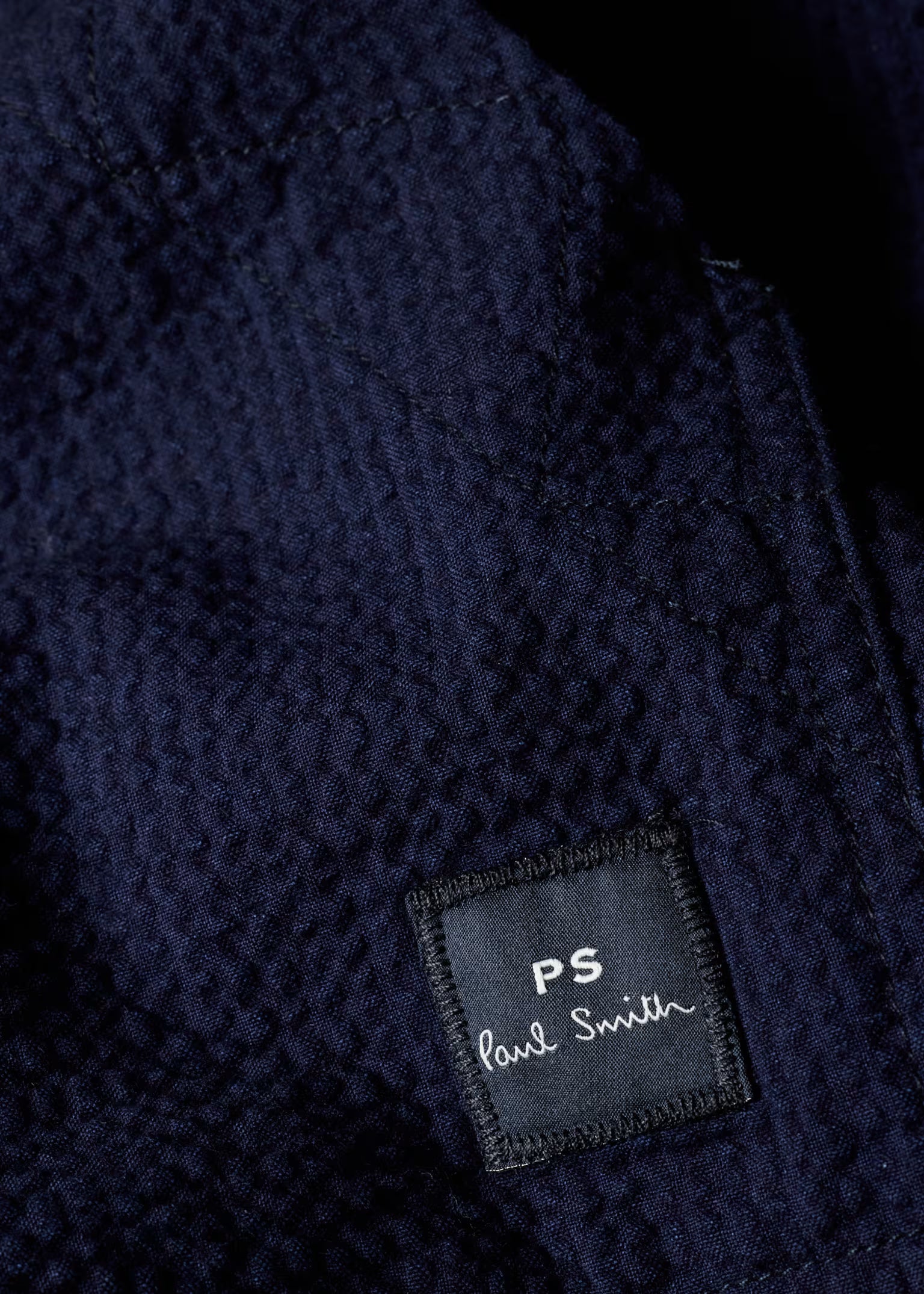 Close-up of a navy blue textured fabric with a 'PS Paul Smith' label.