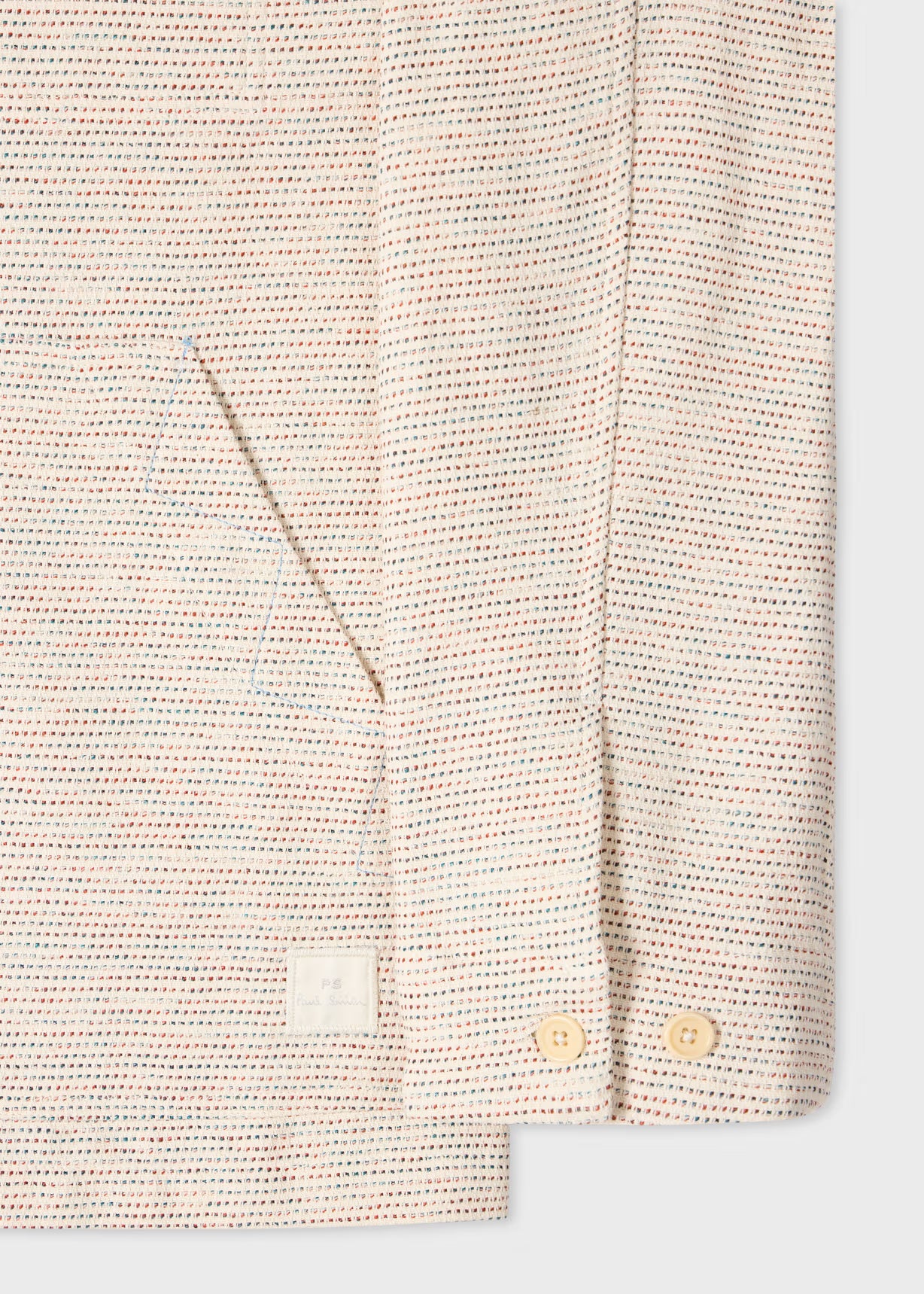 Close-up of a textured shirt with buttons on a light background