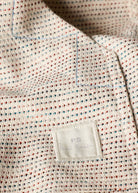 Textured fabric with a visible label on a neutral background