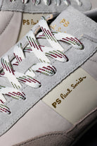 Close-up of a sneaker with white laces and 'PS Paul Smith' branding.