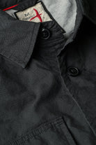 Close-up of a dark coat with a visible brand label inside.
