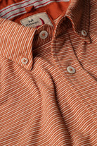 Close-up of a red and white striped shirt with a brand label.