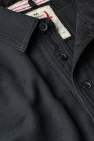 Close-up of a black jacket with a brand label on the collar.