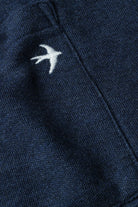 Navy blue fabric with a white embroidered bird design