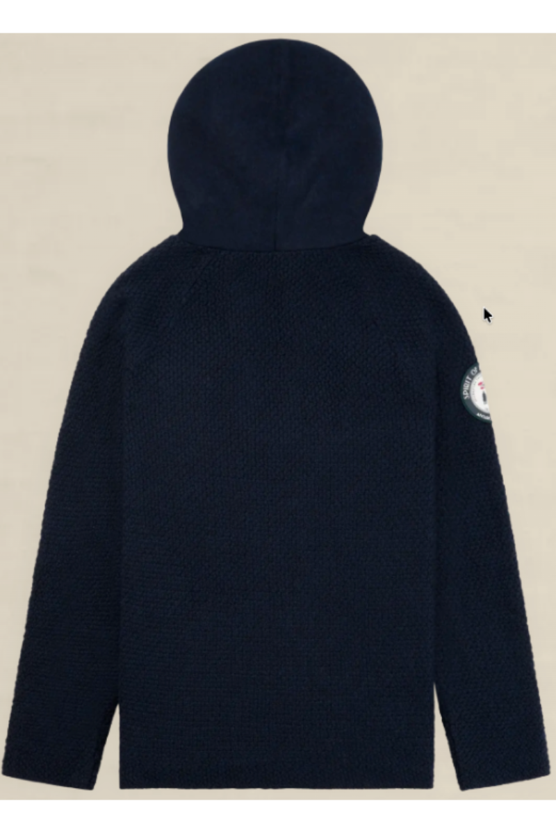 A dark navy blue textured hooded jacket shown from the back, featuring a circular patch on the left sleeve, set against a solid light beige background.