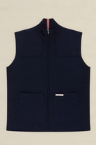 A navy blue zip-up fleece vest with a mock neck, two front patch pockets, and a small white brand label on the lower front pocket, shown flat against a light beige background.
