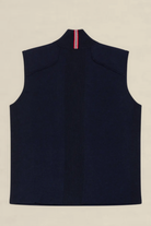 A sleeveless navy blue knit vest shown from the back, featuring a high mock neck with a vertical red, white, and blue striped accent at the collar, laid flat on a light beige background.