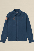A dark blue denim western-style shirt jacket with brown embroidered antlers across the chest, a brown circular patch on the right sleeve, and white buttons, shown against a light beige background.