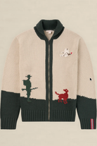 A beige and dark green knit zip-up cardigan sweater featuring a white dog and red rabbit motif on the chest, with a dark green ribbed collar, hem, and cuffs, displayed flat against a light beige background.