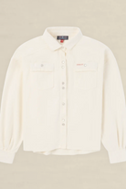 An off-white long-sleeve button-up shirt with two chest pockets, laid flat against a light beige background.