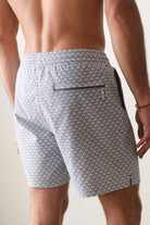 Man wearing gray patterned shorts with a plain background