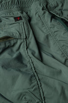Close-up of green pants with stitching details