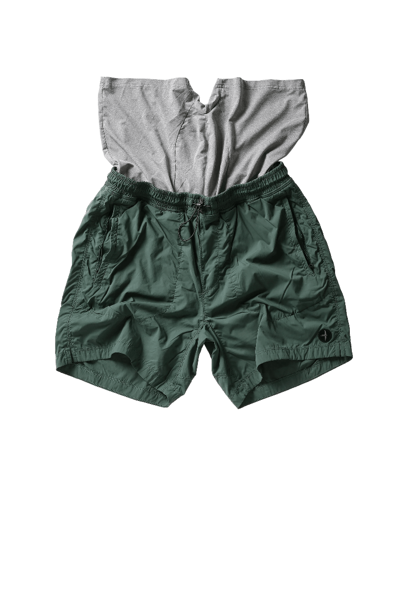 Green shorts with a gray shirt on top on a white background