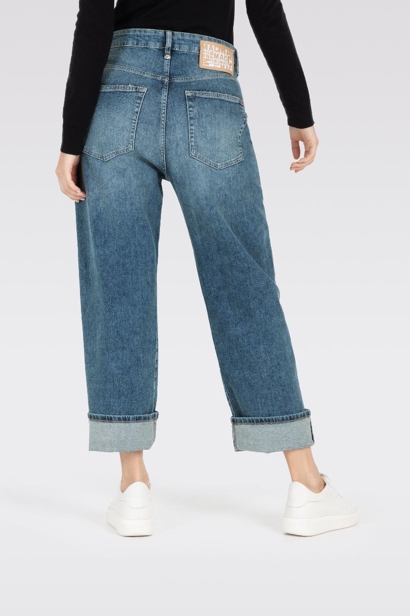 Blue jeans worn by a person on a white background