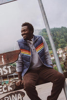 Man sitting on a wooden sign with a scenic background