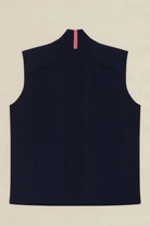 A sleeveless navy blue knit vest shown from the back, featuring a high mock neck with a vertical red, white, and blue striped accent at the collar, laid flat on a light beige background.