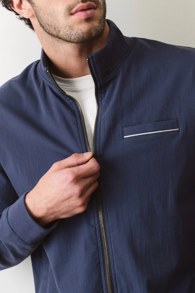 Man wearing a navy blue jacket with a white background