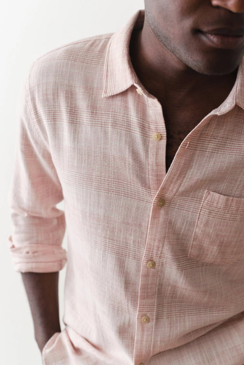 Man wearing a light pink checkered shirt against a white background