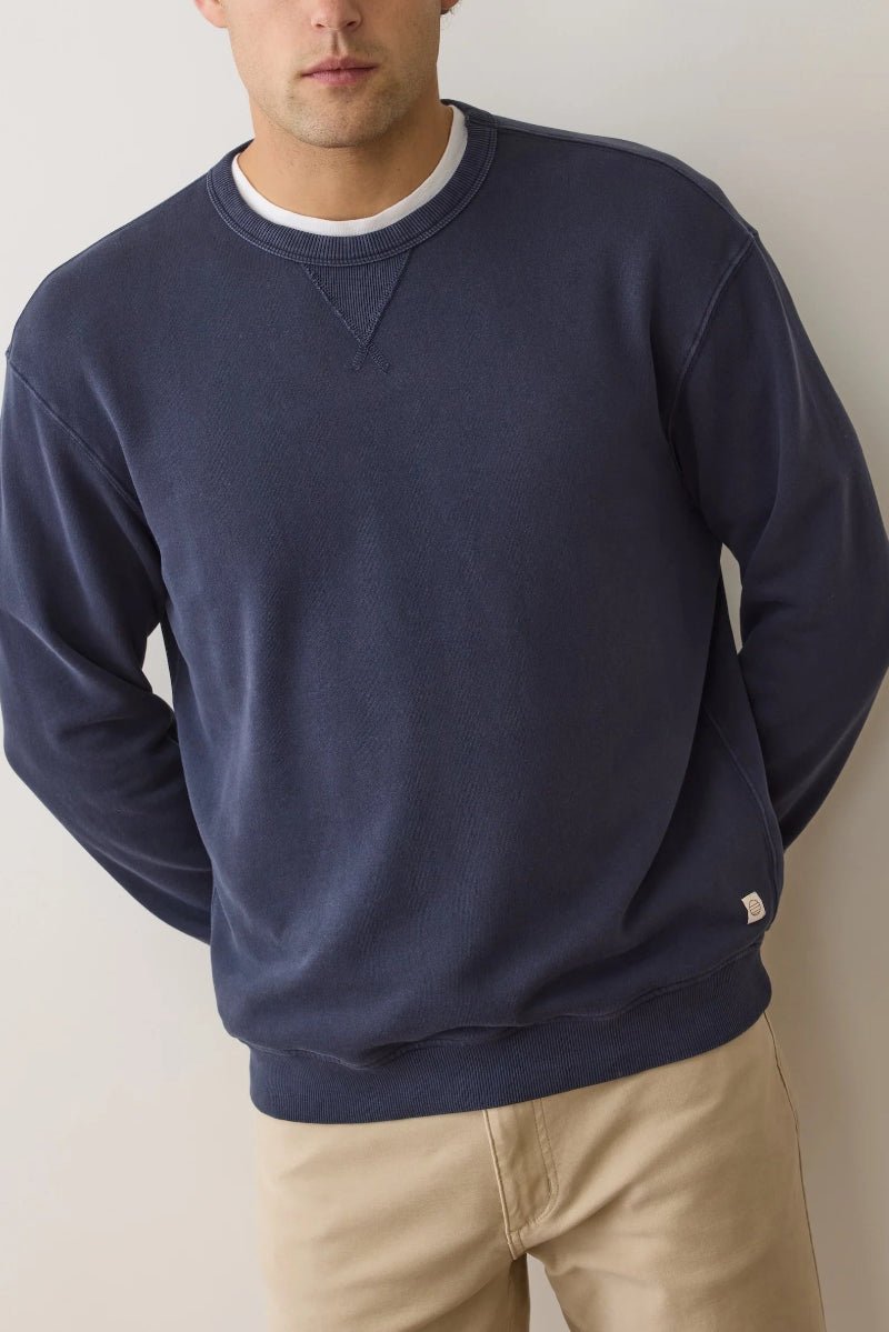 Person wearing a navy blue sweatshirt against a plain background
