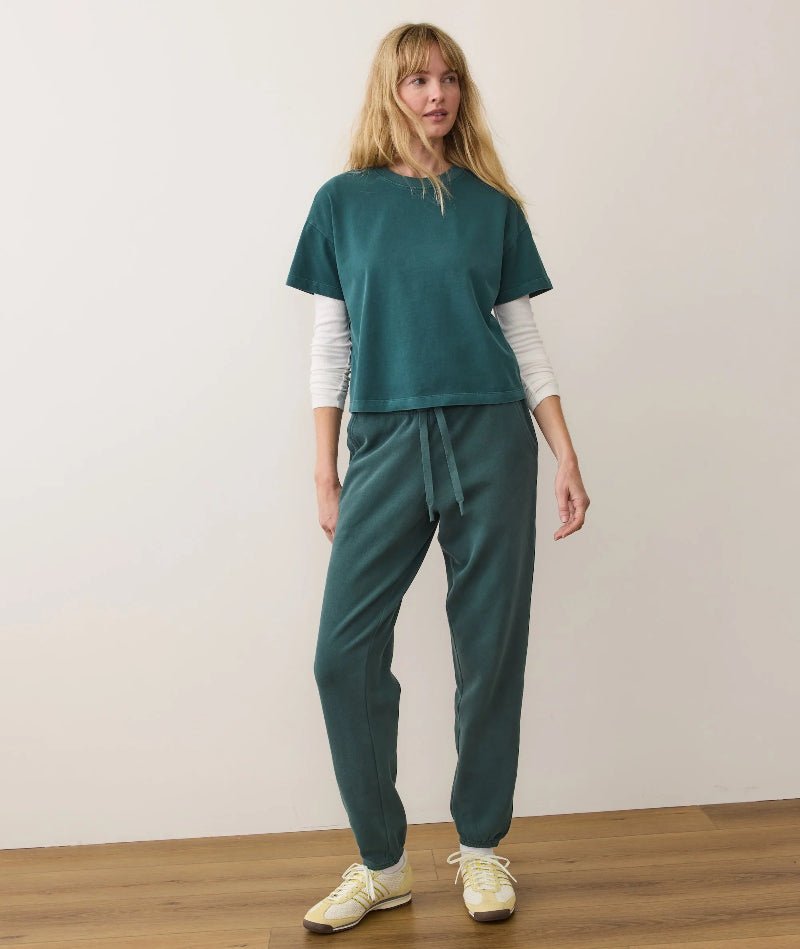 Woman wearing a teal outfit with a white background