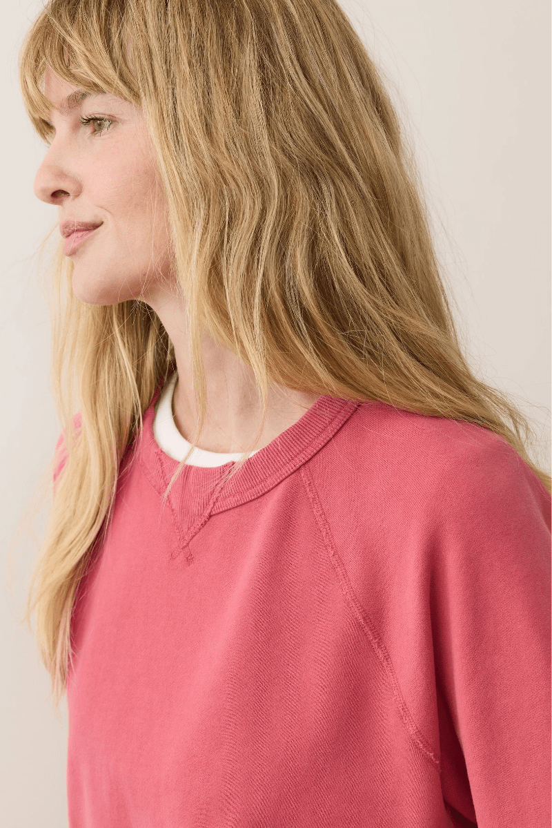 Woman wearing a pink sweater against a plain background