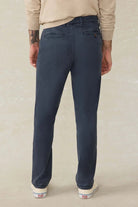 Person wearing navy blue pants on a beige background