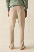 Person wearing beige pants on a plain background
