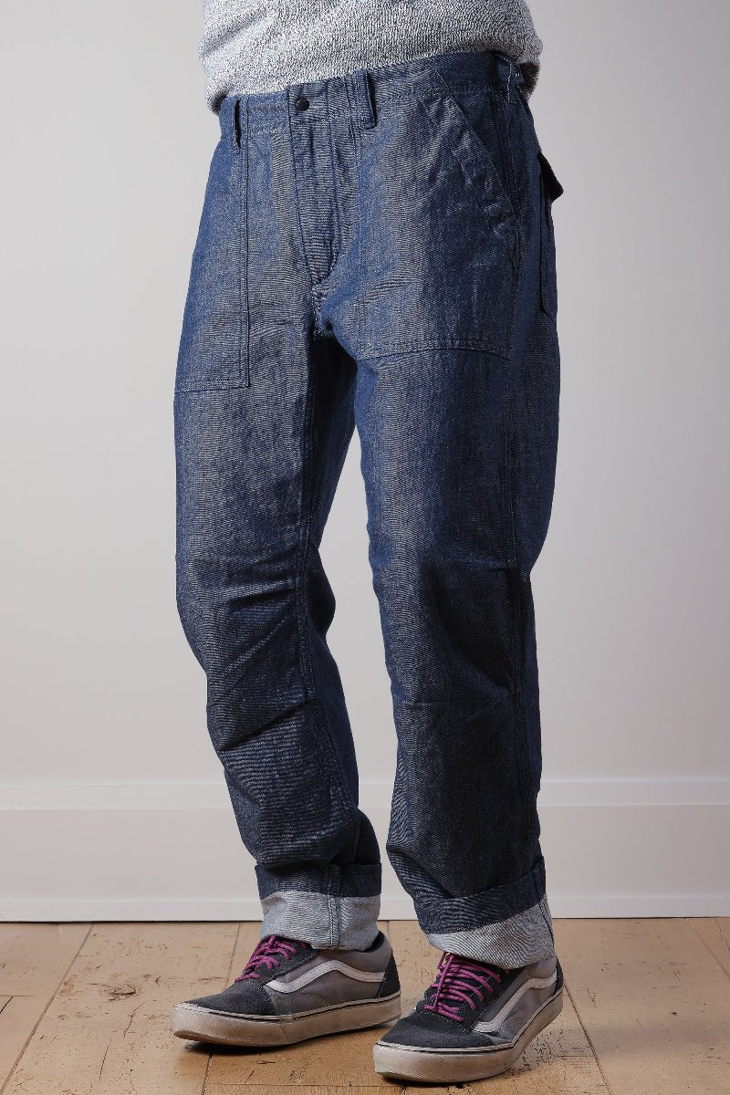 Person wearing blue denim pants with a plain background