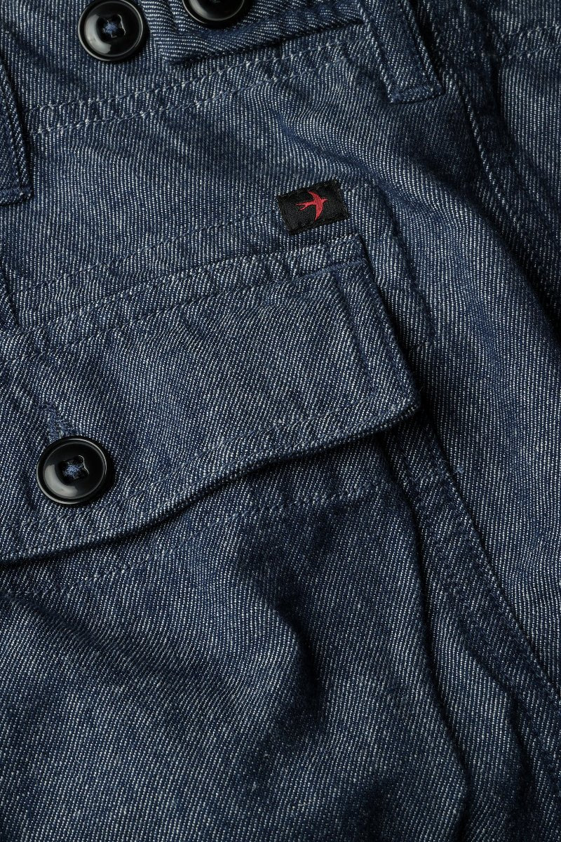 Close-up of a blue denim jacket with buttons and a brand logo.