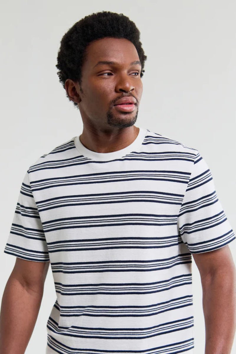 Man wearing a striped t-shirt against a plain background