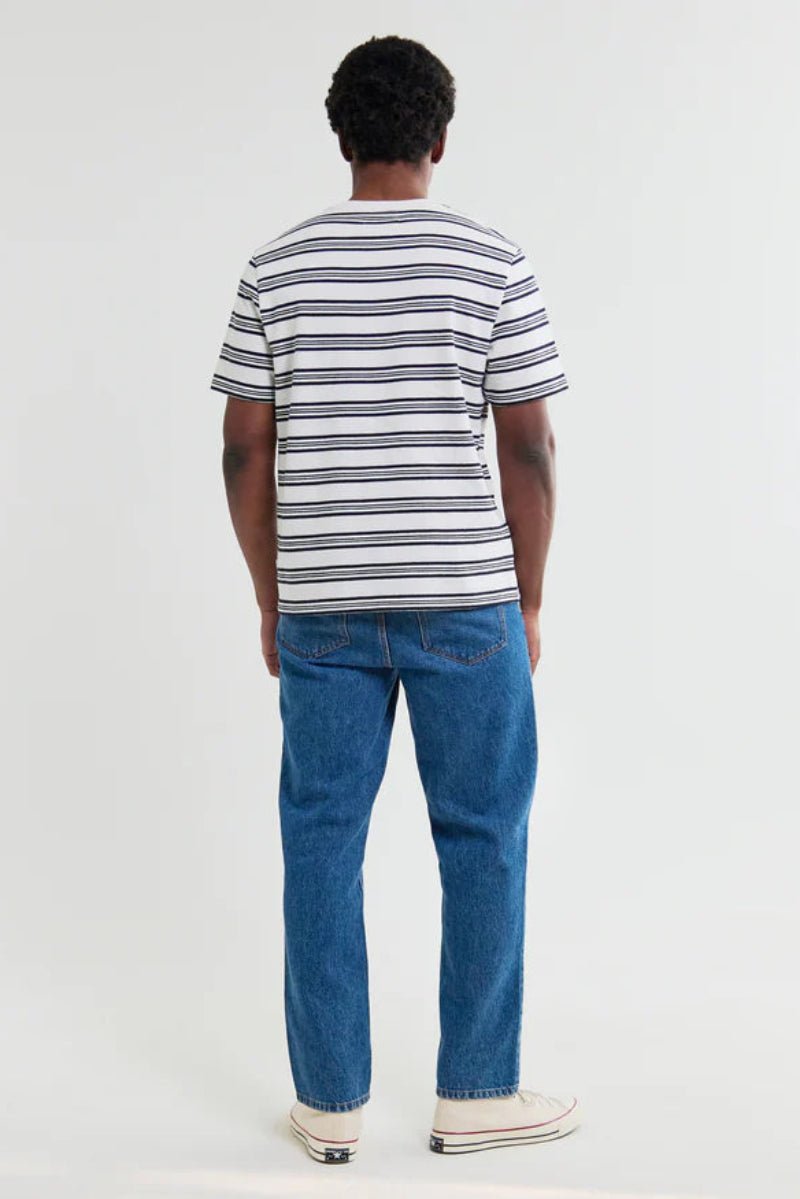 Person wearing a striped shirt and blue jeans on a white background