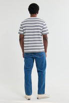 Person wearing a striped shirt and blue jeans on a white background