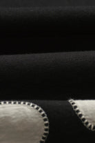 Close-up of black fabric with white stitching details