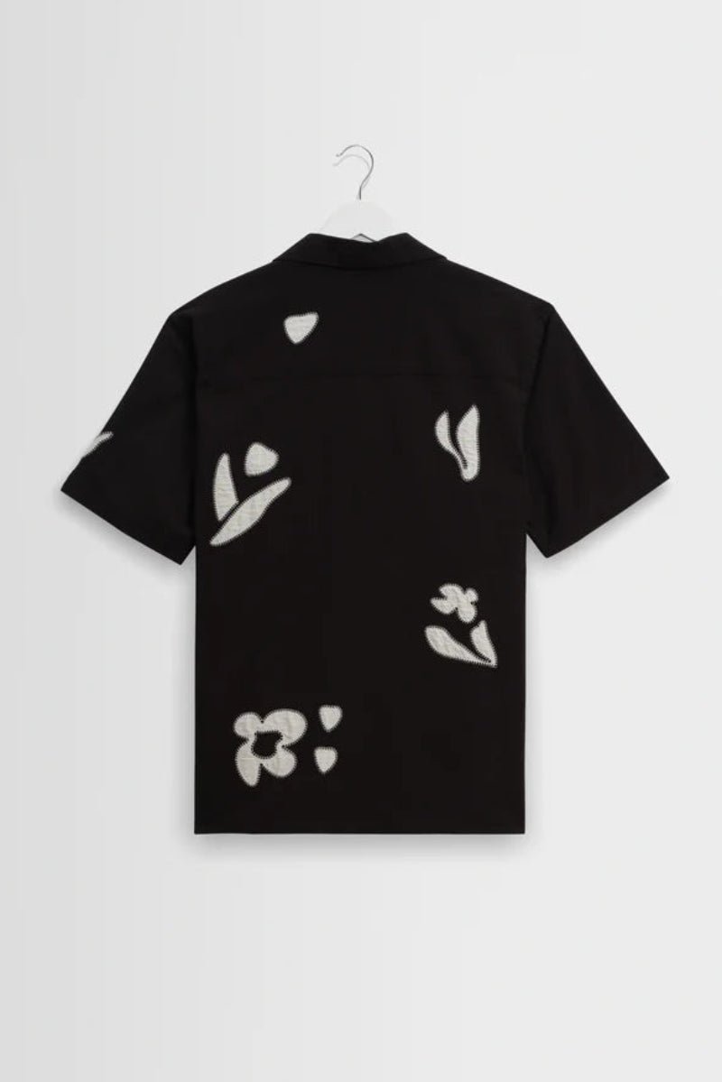 Black shirt with white floral patterns on a white background